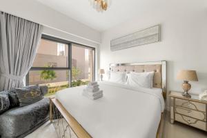 een slaapkamer met een groot wit bed en een bank bij Luxury 2BR with Burj Khalifa Views l Near Dubai Mall in Dubai
