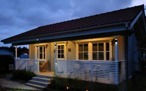 a small white tiny house with a porch at Le cottage des rives de l'Aa labélisé 3 étoiles in Bourbourg +13 photos