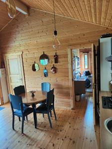 a wooden dining room with a table and chairs at Le cottage des rives de l'Aa labélisé 3 étoiles in Bourbourg