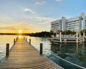a dock with a boat on the water with a building at Aptos Sunrise Beach in San Andrés