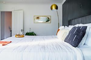 a white bedroom with a large white bed with pillows at Short North Convention King Bed Free Parking! in Columbus +61 photos