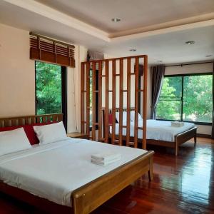 a bedroom with two beds and two windows at The Leaf Pool Villa Resort in Muak Lek District +192 photos