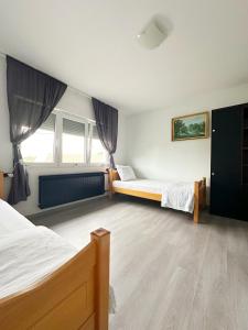 a bedroom with two beds and two windows at Bajkoviti kutak in Ogulin