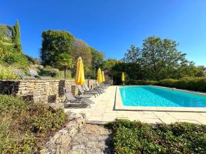 a swimming pool with chairs and umbrellas at Clos de Fougères - La Grange 6-7 personnes in Montoillot