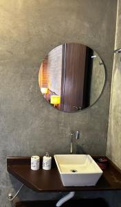 a bathroom with a sink and a mirror at Chalés Retiro dos Manacás in Sapucaí-Mirim +33 photos