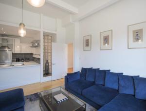 a living room with a blue couch and a table at Large City Centre Apartment Stylish and Spacious in Manchester +22 photos