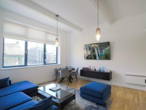 a living room with a blue couch and a table at Large City Centre Apartment Stylish and Spacious in Manchester
