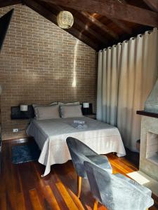 a bedroom with a bed and a fireplace at Chalés Retiro dos Manacás in Sapucaí-Mirim