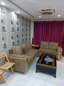 a living room with a couch and a table at One bed apartment in Lahore in Lahore