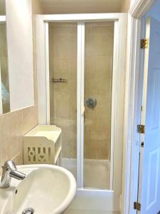 ein Badezimmer mit Dusche, Waschbecken und Badewanne in der Unterkunft Town House with Hot Tub & Free Parking in Central Station