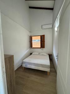 a small bedroom with a bed and a window at Villa Soussoute - à 2mn de la plage de Tartane in La Trinité
