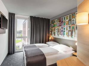 una habitación de hotel con una cama y una ventana en B&B Hotel Lübeck-Hbf, en Lübeck