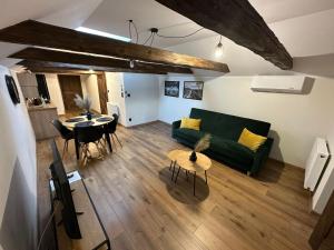 a living room with a green couch and a table at Kamienica LOFT in Ciechocinek