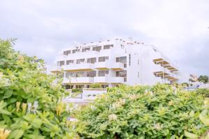 un edificio blanco con arbustos delante de él en WOT Lagos Montemar Soul, en Lagos