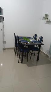 a dining room table with four chairs and a refrigerator at la casita de Daniela in San Miguel +3 photos
