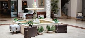 Una fuente en medio de un vestíbulo con plantas en macetas. en Segovia Sierra de Guadarrama, en Los Ángeles de San Rafael