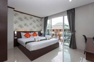 a bedroom with a large bed and a balcony at The Chic Patong Hotel in Patong Beach