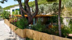 a house with a fence and trees and flowers at Casa del Olivia in Seferihisar