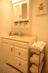 a bathroom with a sink and a mirror and towels at Aqua Bungalow - One mile away from Cove Harbor in Rockport