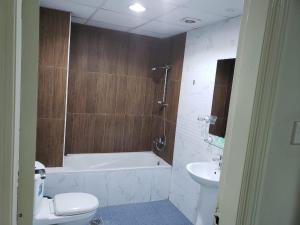a bathroom with a tub and a toilet and a sink at marhaba hotel in Dubai
