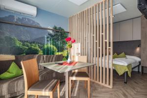 a dining room with a table and chairs and a large window at RAMSI euer Familienhotel in Hermagor +74 photos