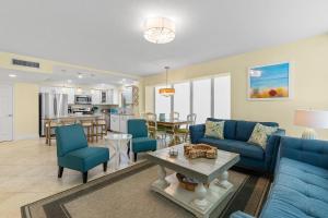 a living room with blue couches and a kitchen at Golden Arms 101 in Chicken Island