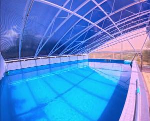 a large indoor swimming pool with blue water at Guest house Al Meri in Travnik