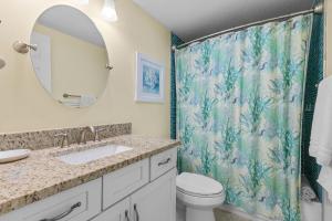 a bathroom with a shower curtain and a toilet at Golden Arms 101 in Chicken Island +36 photos