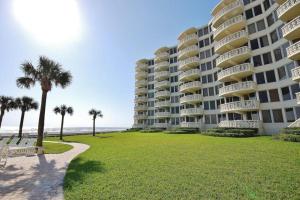 a large apartment building on the beach with palm trees at Golden Arms 101 in Chicken Island