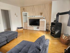 ein Wohnzimmer mit Couch und Flachbildfernseher in der Unterkunft Ferienhaus am Gupfen in Weilheim