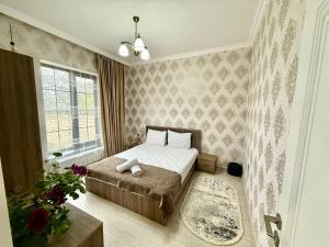 a small bedroom with a bed and a window at Villa Gabala in Gabala