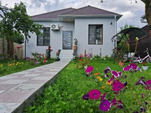 a white house with flowers in the yard at Villa Gabala in Gabala