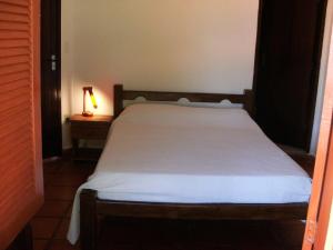 un letto in una camera da letto con una lampada su un tavolo di Casa aconchegante emTabatinga Beach Nisia Floresta RN a Nísia Floresta