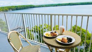 Una mesa con dos platos de comida y una bebida en un balcón. en Blue Heron Beach Resort pet friendly, en Orlando