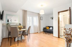 a dining room and living room with a table and chairs at Stepup Apartment, Downtown Bucharest, City Center, Garden View in Bucharest