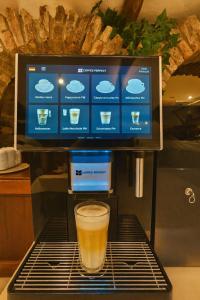 ein Glas Bier steht auf einem Gestell mit einer Kaffeemaschine in der Unterkunft Atomis Hotel Düsseldorf City in Düsseldorf + 23 Fotos