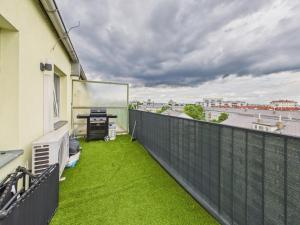 a balcony with green grass and a desk at Luxus Apartment in Vienna