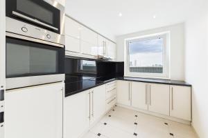 a kitchen with white cabinets and a window at Luxus Apartment in Vienna