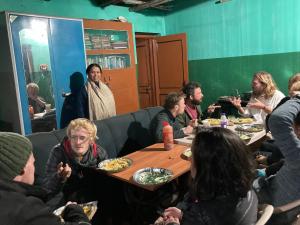 a group of people sitting around a table eating food at Ansari House in Bodh Gaya