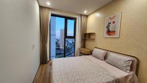 a bedroom with a bed and a large window at Căn hộ 12A11 Chung cư Sentosa Sky Park - Hải Phòng in An Khê