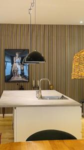 a kitchen with a sink and a wall with stripes at OlofPalmesApartment Premium in Stockholm
