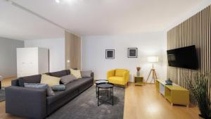 a living room with a couch and a yellow chair at OlofPalmesApartment Premium in Stockholm +12 photos