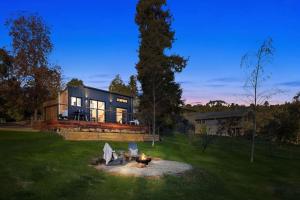 ein großes Haus mit einer Feuerstelle im Hof in der Unterkunft Tiny Grace - Boutique Yarra Valley Accommodation in Healesville