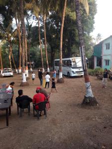 un gruppo di persone seduti su sedie sotto le palme di Ekta Visava ad Alibaug Altre 4 foto