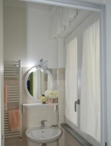 un bagno bianco con lavandino e specchio di Ica house a Castellammare di Stabia