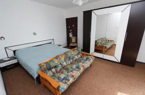 sypialnia z łóżkiem, kanapą i lustrem w obiekcie Apartments Rosanna w Rovinj