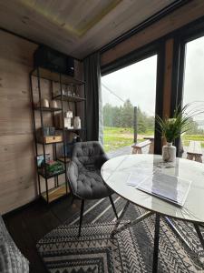 a room with a table and a chair and a window at Melnā kalna kamene in Vestiena