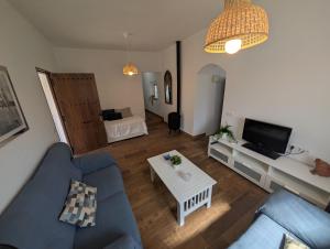 a living room with a blue couch and a table at Livingtarifa Casa Luz in Facinas