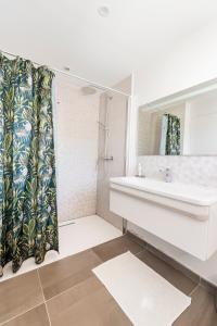 un bagno con lavandino e specchio di Paisible maison à 2 pas du Bassin ad Arès