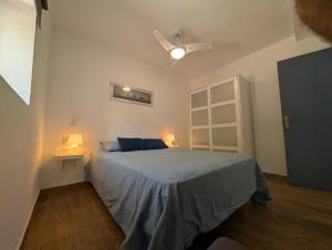 a bedroom with a bed and a ceiling fan at Livingtarifa Casa Luz in Facinas